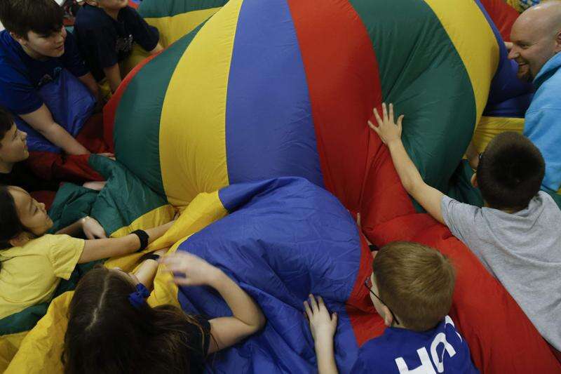 Heath Mueller with PE students playing with parachute